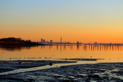 Scenic view of sea against orange sky