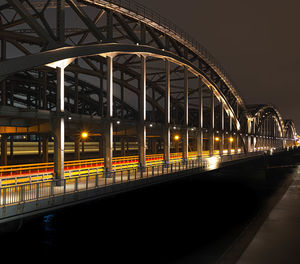 Illuminated railroad station platform against sky at night