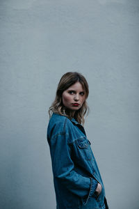 Thoughtful woman wearing denim jacket while standing outdoors