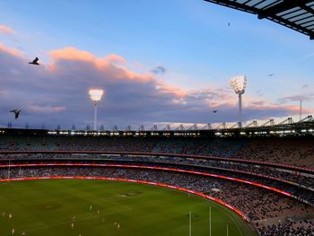 High angle view of soccer field against sky at sunset