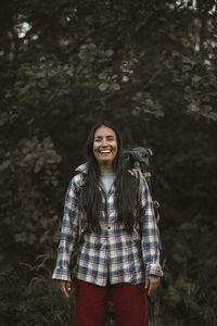 Portrait of smiling woman standing in forest