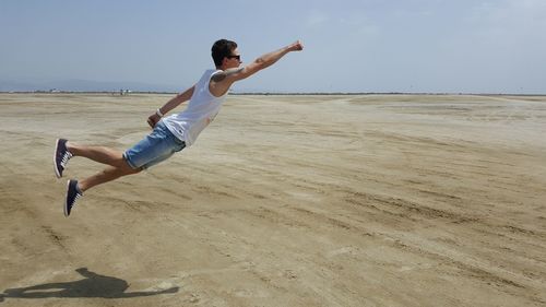 Side view of man levitating at beach