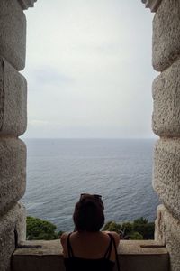 Rear view of people looking at sea against sky