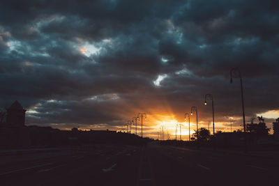 View of city street against cloudy sky