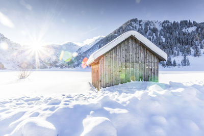 Houses on snow covered landscape against sky