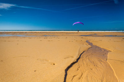 Scenic view of beach against blue sky