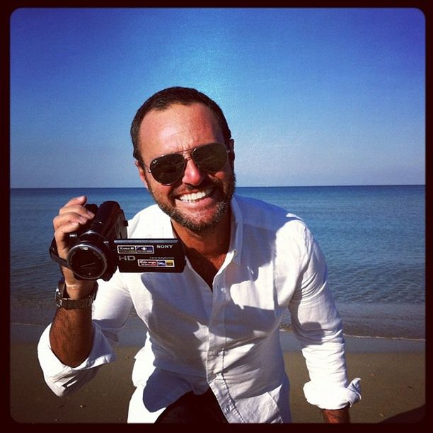 PORTRAIT OF MID ADULT MAN AGAINST BEACH