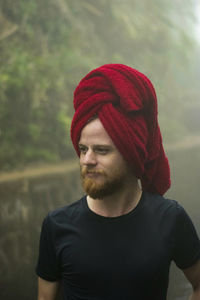 Man with hair wrapped in towel looking away