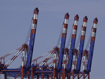 Low angle view of cranes against sky