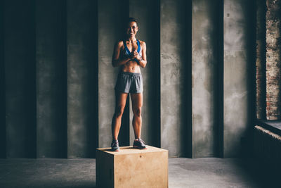 Rear view of woman standing against wall