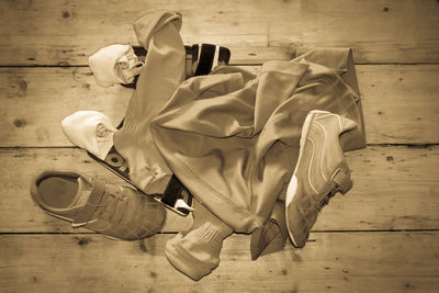 High angle view of clothing by shoes on wooden floor
