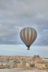 Hot air balloon flying over landscape against sky