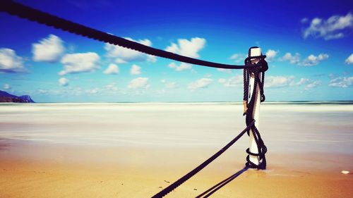 Close-up of rope on beach against sky