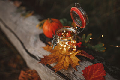 Close-up of autumn leaves in jar on table