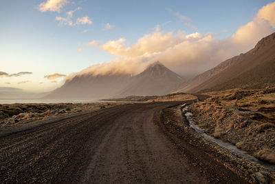 Road amidst mountains against sky during sunset