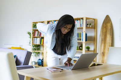 Pregnant female freelancer using laptop while working at home