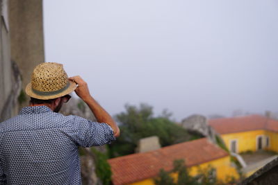 Rear view of man standing against built structure