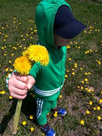 Midsection of person holding yellow flowering plant