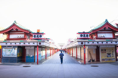 Rear view of people walking on building