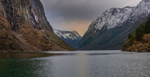 Scenic view of lake by mountains against sky