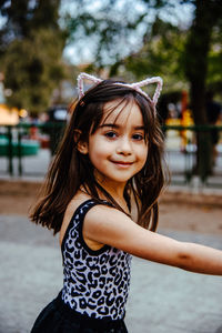 Portrait of cute girl while standing on road against sky