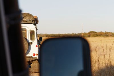 Off road vehicle on field against clear sky