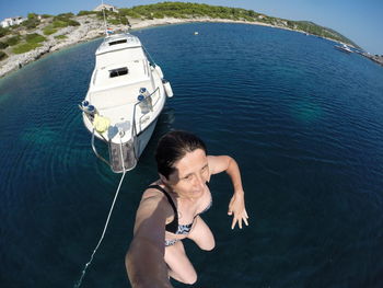 High angle view of woman diving in sea against boat
