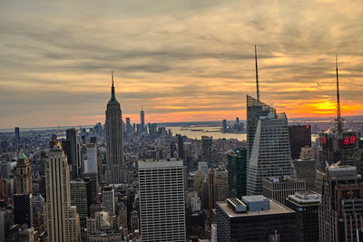 Modern buildings in city against cloudy sky