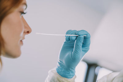 Close-up of patient giving nasal swab in examination room during covid-19