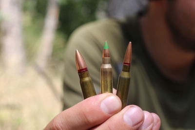 Cropped hands of man holding bullets