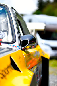 Close-up of yellow car on road