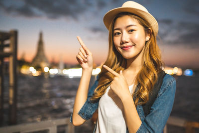 Portrait of smiling young woman standing outdoors