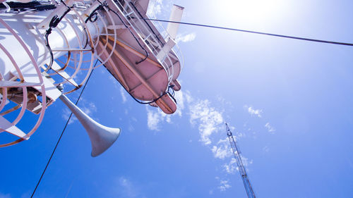 Low angle view of radar on ship against blue sky