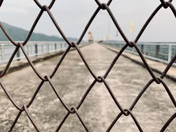 Close-up of chainlink fence against sky