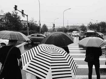 Rear view of people walking on road in rain