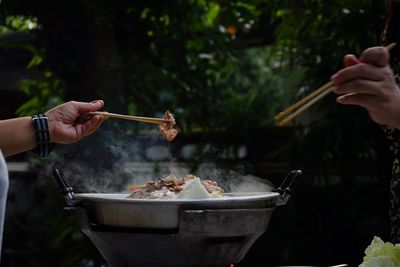 Close-up of people eating food with chopsticks