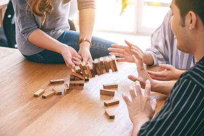 Midsection of friends playing with table