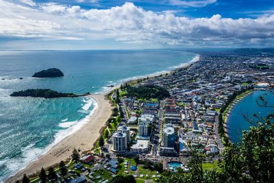 High angle view of town by sea against sky