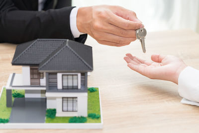 Midsection of man holding umbrella on table in building