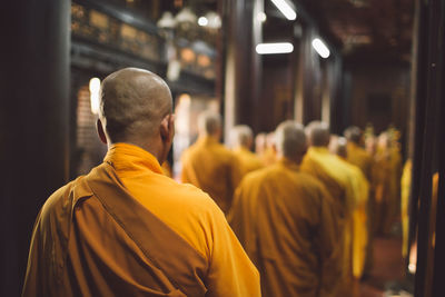 Rear view of monks standing at temple