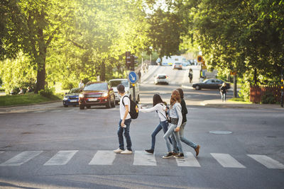 Side view of teenagers crossing road