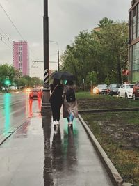 Man with umbrella on street during rainy season