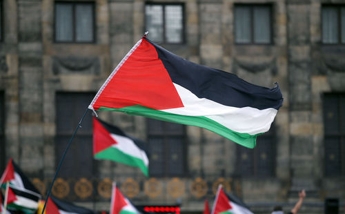 Close-up of flag against buildings in city