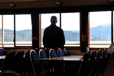 Rear view of man sitting at home