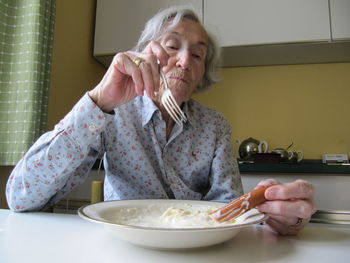 Young woman sitting on table at home