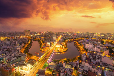 High angle view of illuminated city against sky during sunset