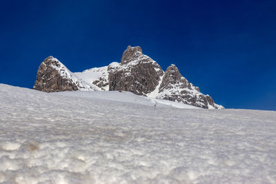 Scenic view of snowcapped mountains against clear blue sky