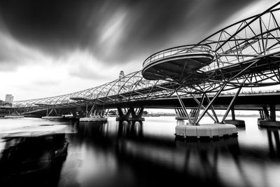 Bridge over river against cloudy sky