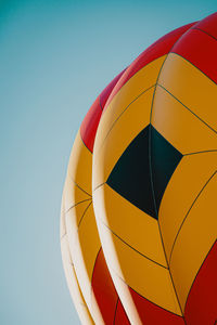 Low angle view of multi colored umbrella against clear blue sky