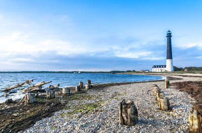 View of lighthouse by sea against sky